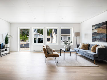 Bilde av stue med lave vinduer og helglasset balkongdør