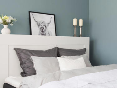 Bilde av blått soverom med pynteputer i senga