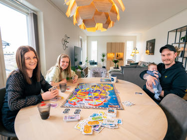 Bilde av familie jublende i huset sitt