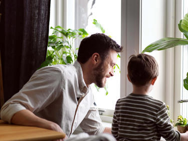 Bilde av far og sønn som tittet ut av vinduet
