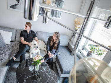 Bilde av paret som slapper av i sofaen sin med hunden
