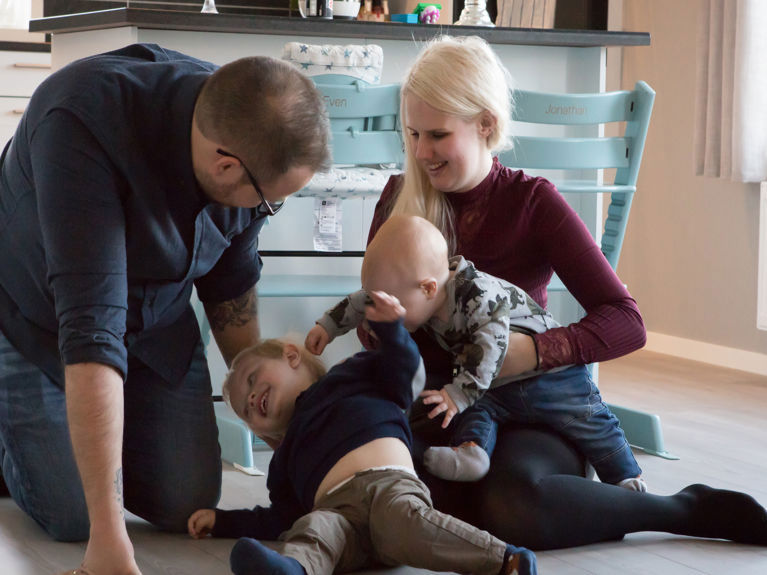 Bilde av familien lekende på stuegulvet