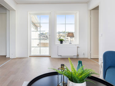 Bilde av TV-stue med sprosser, lavt vindu og helglasset balkongdør