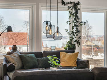 Bilde av stue med lave vinduer og helglasset balkongdør i huset Åse