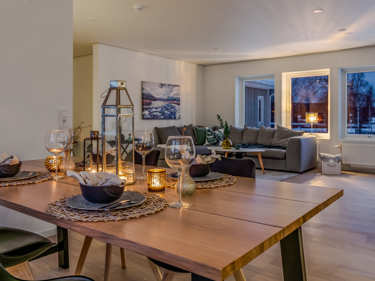 Kveldsbilde av spisestue og stue i vinkelhuset Regina