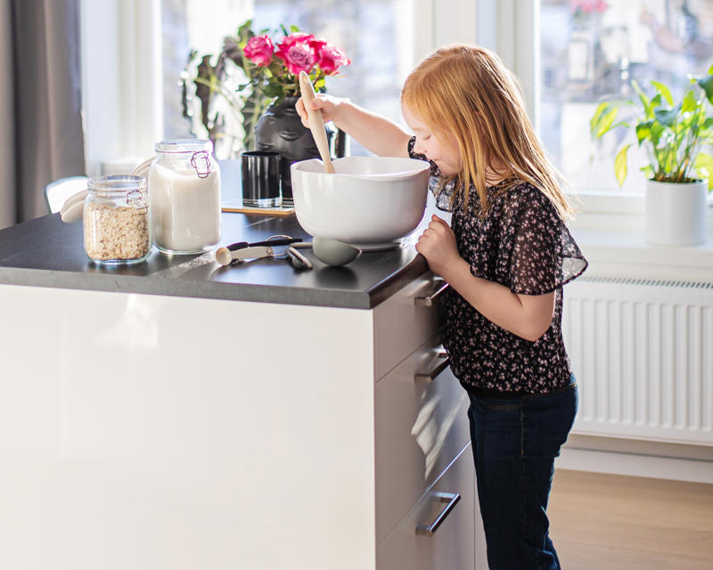 Bilde av barn som baker kake ved kjøkkenøy på kjøkkenet