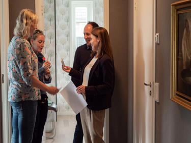 Bilde av boligformidler Anita Milje som snakker med potensielle kunder