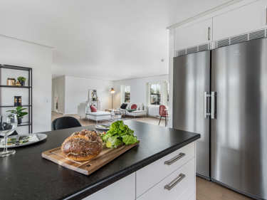 Bilde av kjøkkenøy og vridd kjøl/frys i retning stue - husmodellen Linnea
