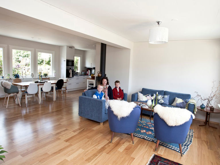 Bilde av familien samlet i stua i sitt nye Älvsbyhus