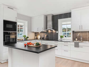 Bilde av kjøkken med kjøkkenøy, spotlights og hvitevarer fra Electrolux