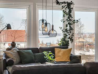 Bilde av stue med lave vinduer og helglasset balkongdør i huset Åse