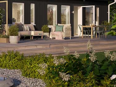 Sommerbilde av hagen til ferdighuset Maja+ med utleiedel