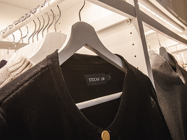 Nærbilde av jakker som henger i  klesskapet på soverommet