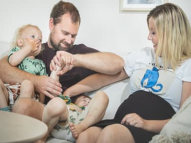 Bilde av familien samlet i sofagruppen
