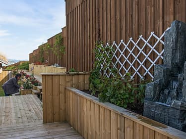Bilde av uteplass med hjemmesnekrede blomsterbed