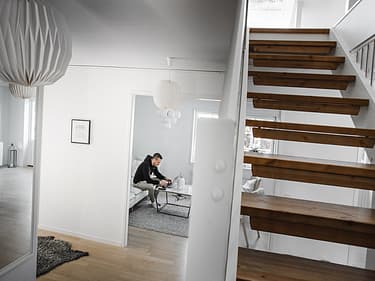 Bilde av huseier i stuen og trapp til andre etasje