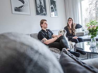 Paret som har bygget hus sitter i sofaen sin