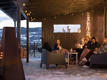Bilde fra kundecase med hele familien sittende ute på verandaen