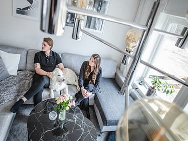 Bilde av paret som slapper av i sofaen sin med hunden