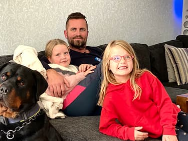 Bilde av hele familien samlet i sofaen i stua