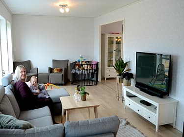Bilde av mor og barn i sofaen i stuekroken