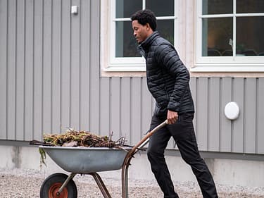 Bilde av huseier som er ute å steller med hagen