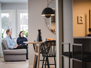 Bilde av både sittegruppe og sofakrok hvor paret sitter