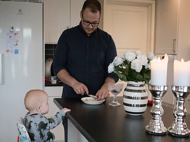 Bilde av far og ene sønnen som holder på på kjøkkenet
