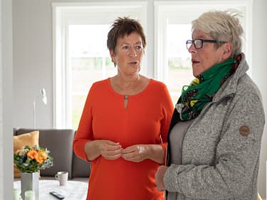 Bilde av to som står å snakker sammen i visningshuset