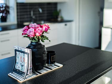 Bilde av blomster i en vase plassert på kjøkkenøya