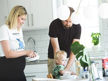 Bilde av familien som rydder opp etter frokost