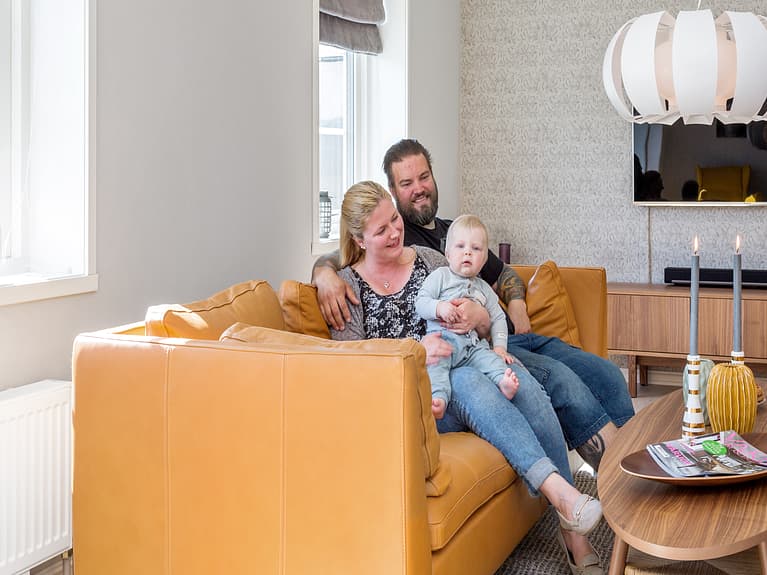 Bilde av familien samlet i sofaen i stua