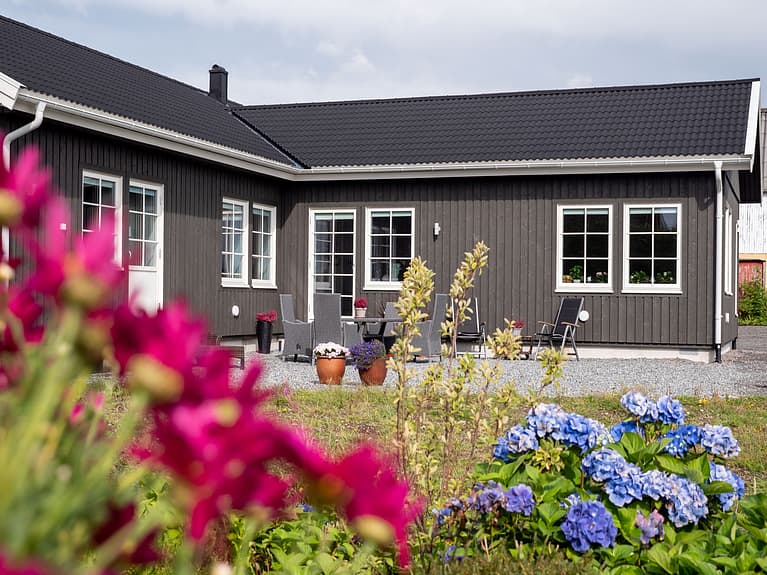 Bilde av vinkelhus på tomt med flott hage